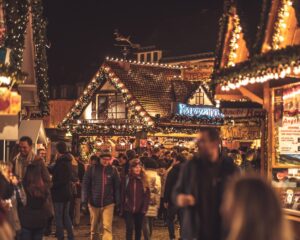 a crowd of people walking in a crowded area with lights weihnachtsmarkt tangermünde